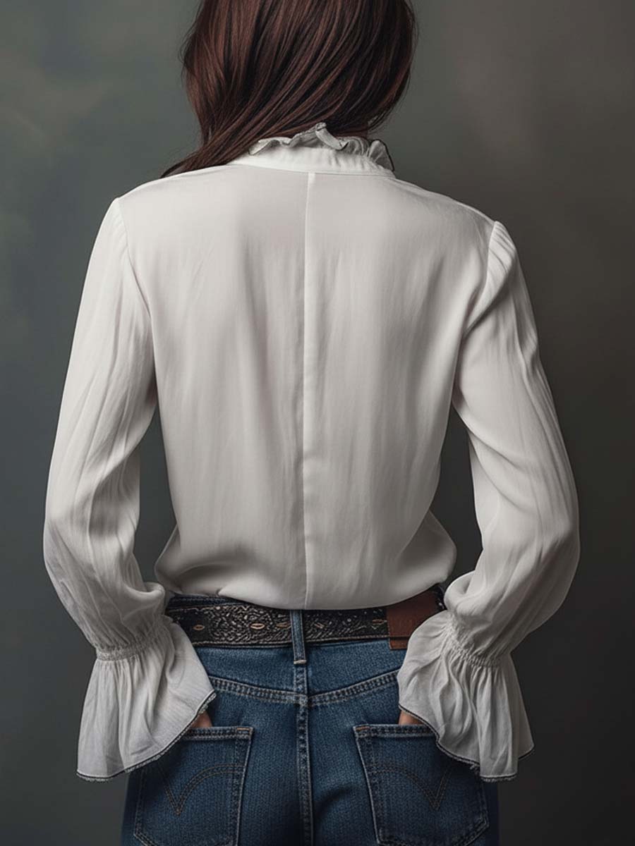 Abbigliamento femminile: blusa elegante con maniche lunghe, scollo convertibile e polsini a volant chic.