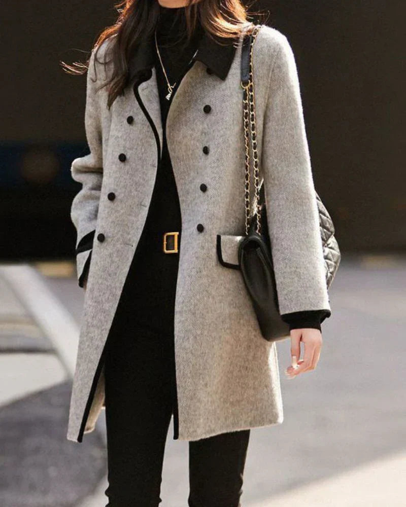 Cappotto donna grigio elegante, lungo con bottoni e dettagli a contrasto. Abbigliamento invernale classico e versatile.