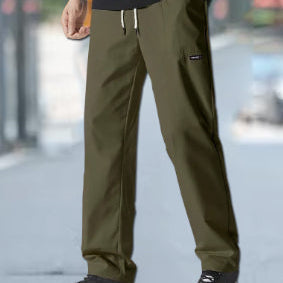 Uomo indossa pantaloni cargo a gamba dritta, vestibilità ampia. Look casual e confortevole per il giorno.
