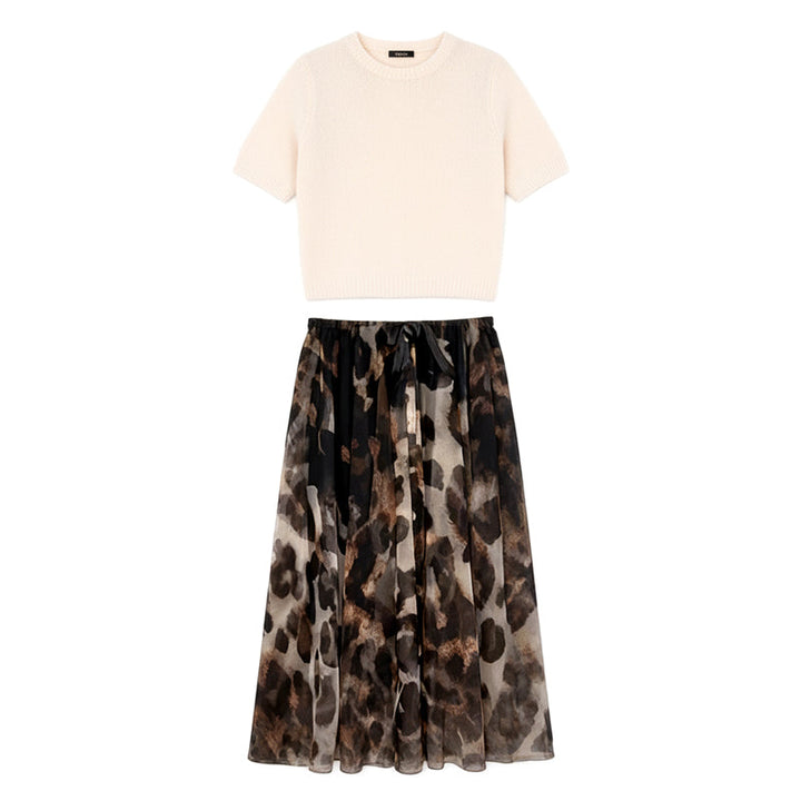 Modella indossa completo donna due pezzi autunnale: maglione girocollo e gonna midi leopardata per un look casual-chic.