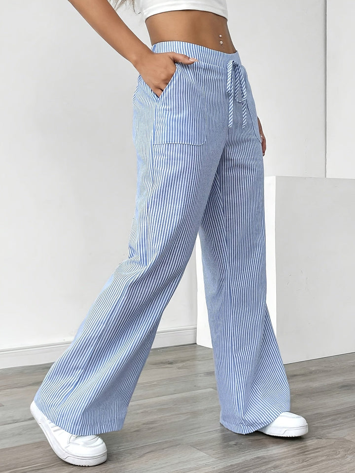 Eleganti pantaloni fluidi da donna a righe verticali, vita alta e gamba larga per primavera estate.