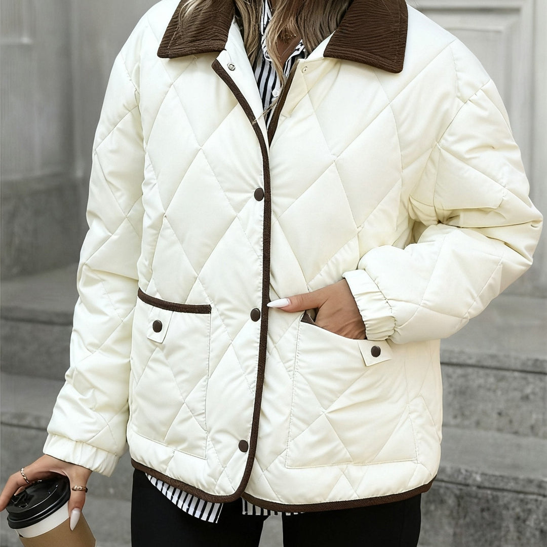 Tessuto trapuntato della giacca donna marrone caffè, con collo a contrasto bianco latte, stile chic e comfy.