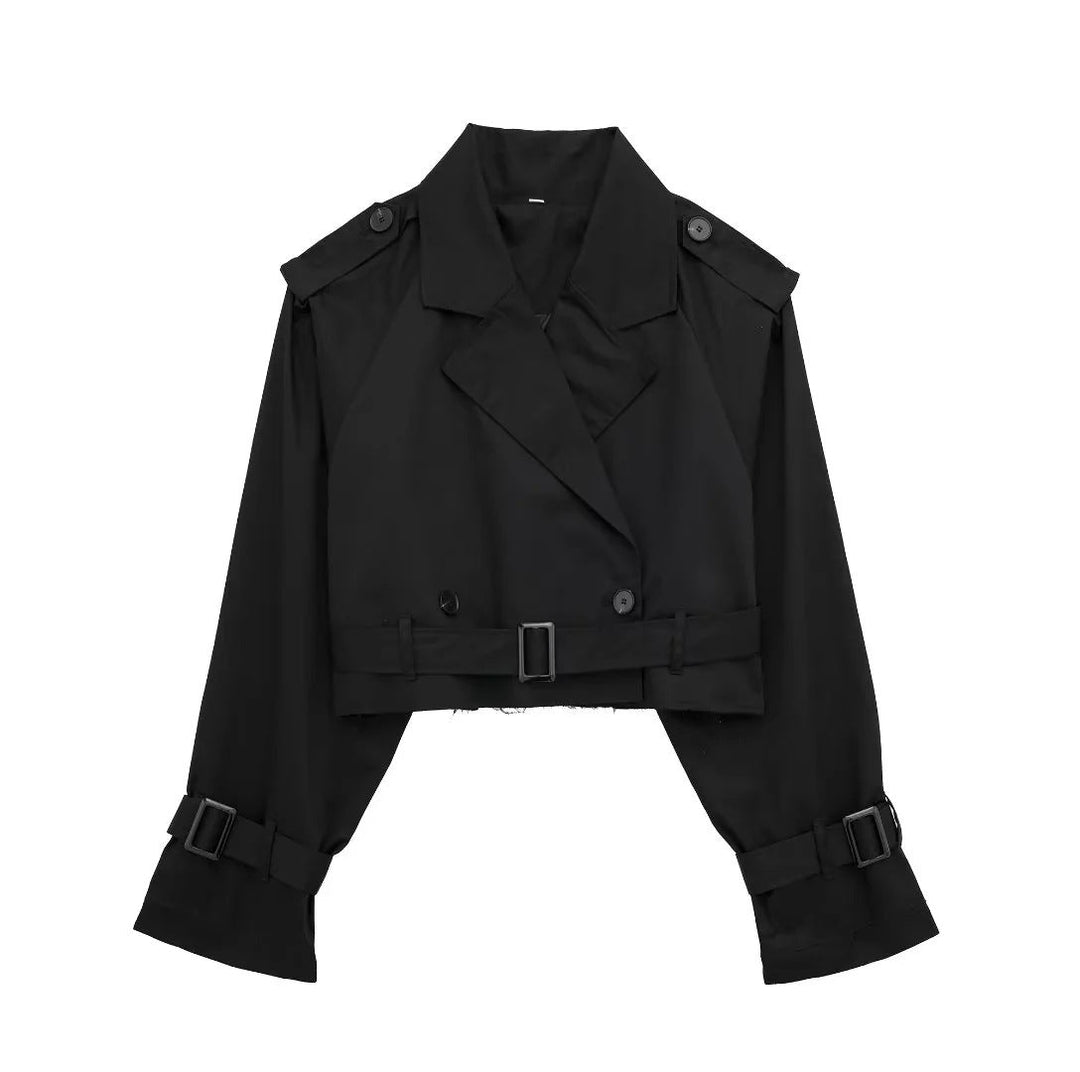 Donna indossa trench primaverile corto doppiopetto con cintura, outfit moda per la nuova stagione.