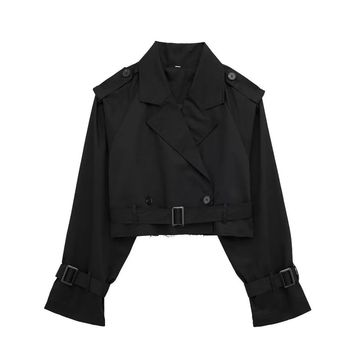 Donna indossa trench primaverile corto doppiopetto con cintura, outfit moda per la nuova stagione.