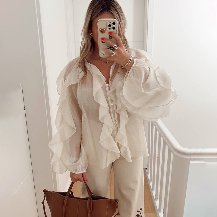Blusa donna casual chic con scollo rotondo, maniche lunghe ampie e dettagli volant. Stile comodo ed elegante.