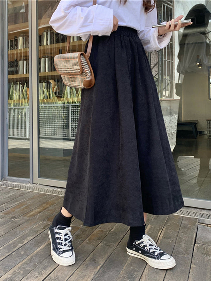 Gonna midi donna trendy a vita alta con orlo svasato. Stile elegante e moderno, perfetta per autunno/inverno.