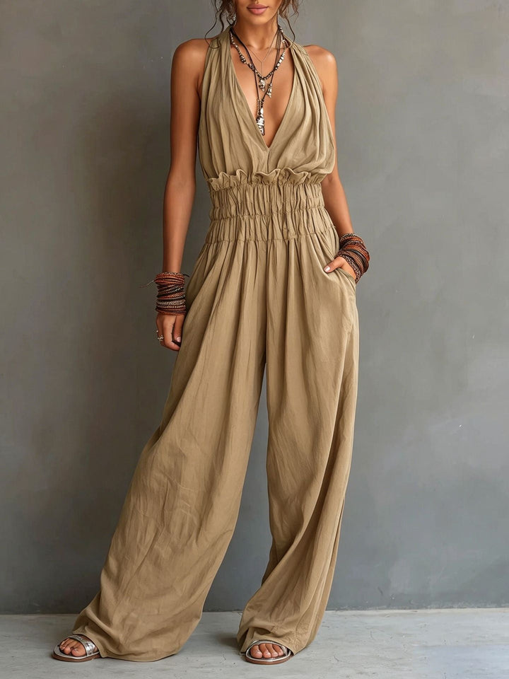 Tuta donna con allacciatura al collo, schiena scoperta e pantaloni larghi, per un look estivo elegante e raffinato.