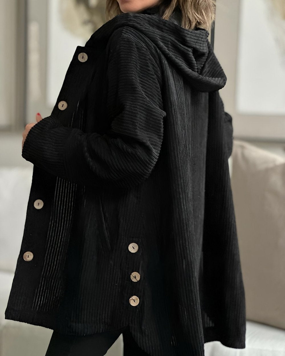 Giacca invernale nera per donna, con cappuccio e tasche frontali, ideale per un look casual e protettivo.