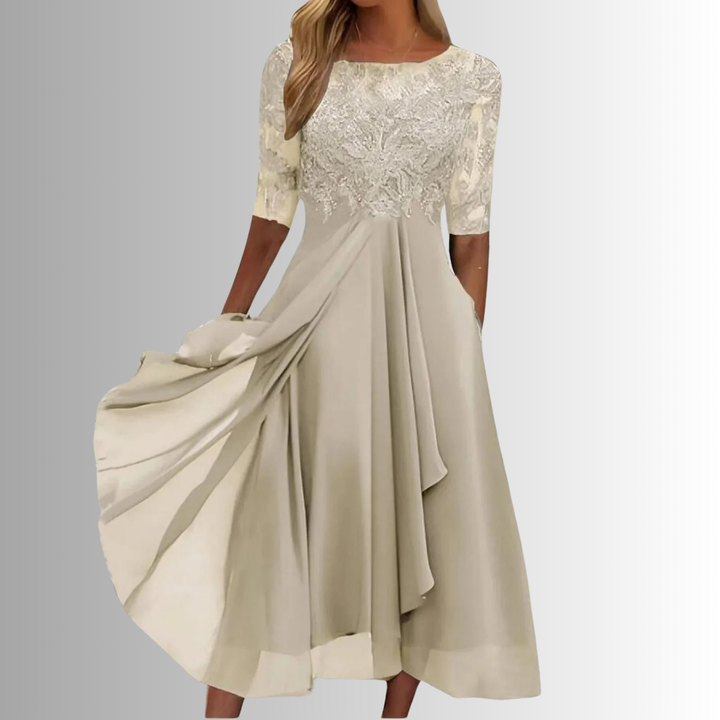 Primo piano del raffinato pizzo floreale sul corpetto dell'abito midi, con gonna fluida in chiffon.