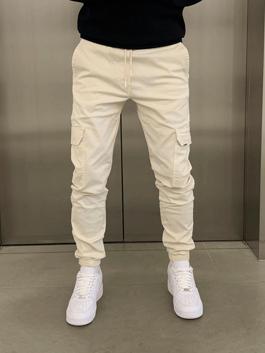Uomo con pantaloni cargo jogger slim fit, abbigliamento versatile per un look casual chic.