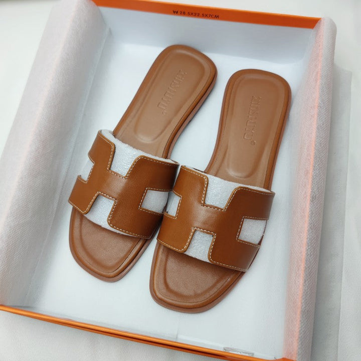 Moda donna: sandali marroni con fasce ad H, tacco basso elegante. Ideali per outfit estivi chic.