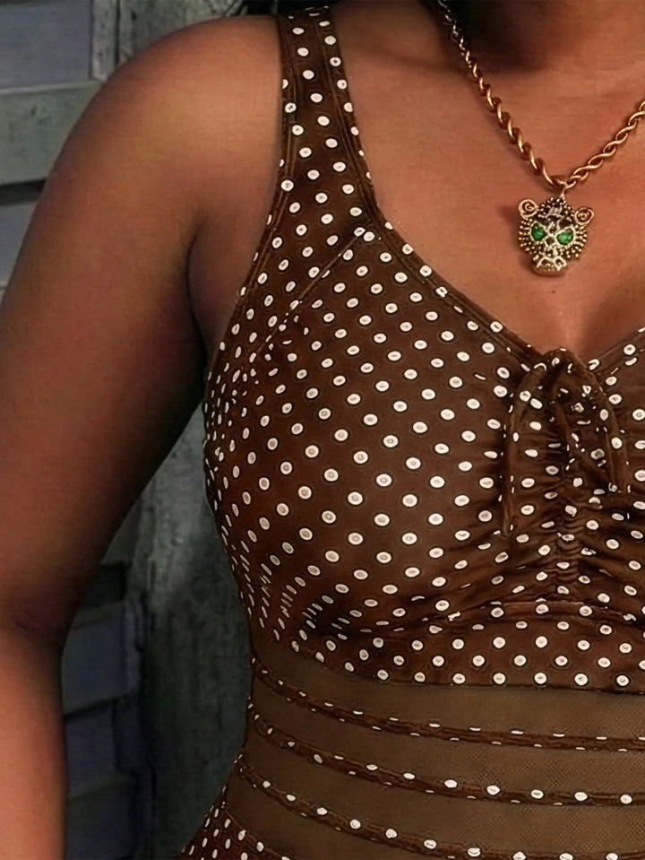 Costume da bagno intero femminile tropicale, stampa palme verdi e inserti laterali in rete nera.