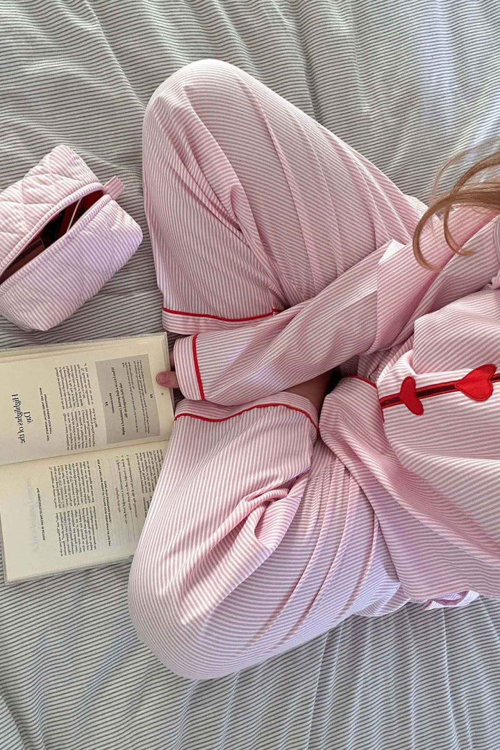 Modella indossa pigiama da donna due pezzi con cuori, abbigliamento casa confortevole per relax e notte.