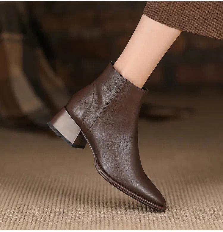 Dettaglio texture stivali donna in pelle nera, tacco basso. Perfetti stivaletti comodi per un look raffinato.