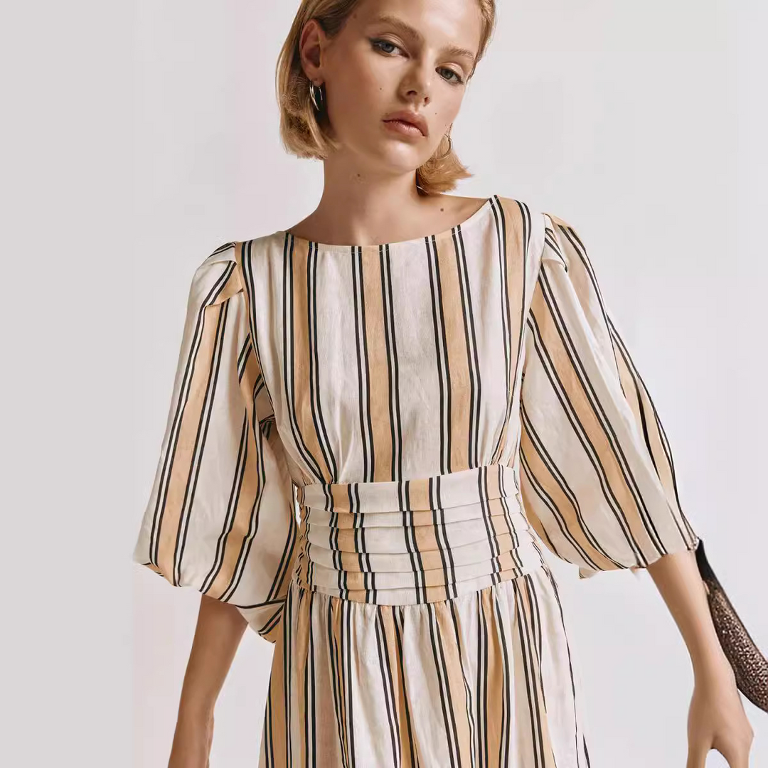 Elegante abito midi fluido da donna, ideale per eventi estivi. Look sofisticato senza maniche color cachi.