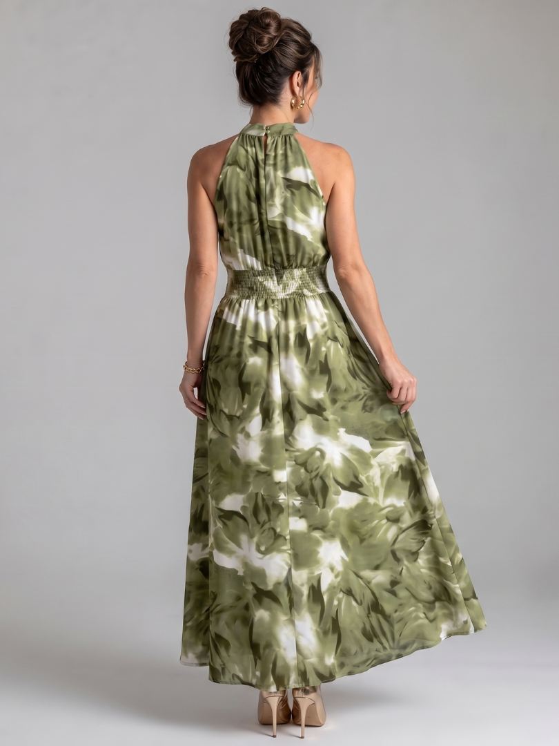Donna indossa abito midi elegante con stampa astratta e vita arricciata, per un look chic e di tendenza.