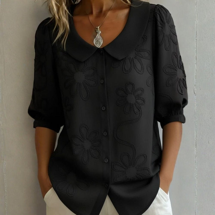 Blusa donna elegante con dettagli floreali e colletto arrotondato. Camicetta femminile per ogni occasione.