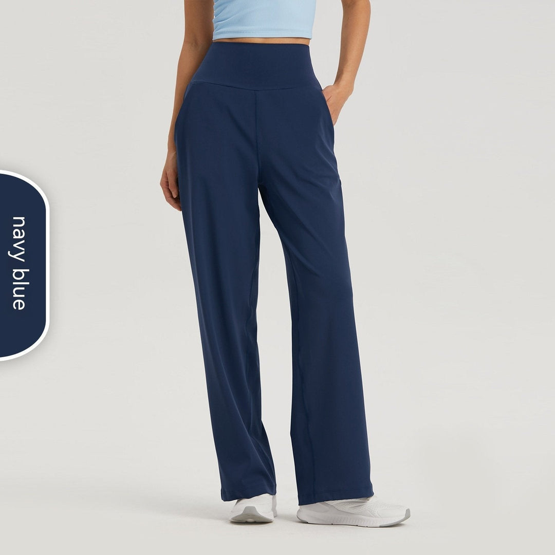 Modella in pantaloni yoga donna a vita alta, gamba larga, esegue posa. Massima libertà di movimento per lo sport.
