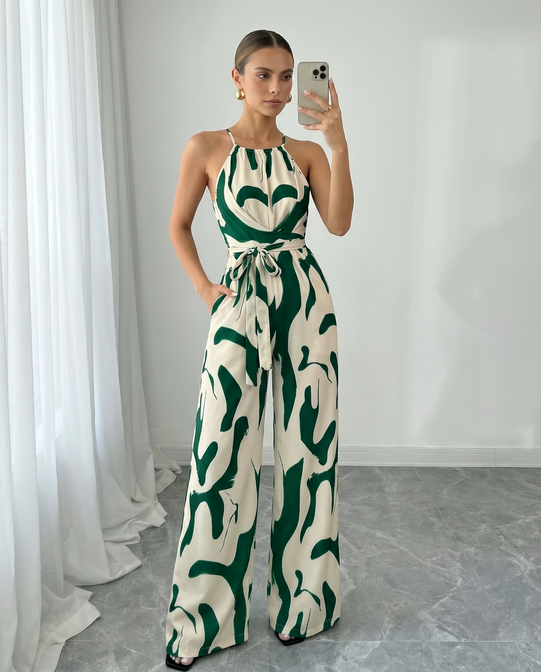 Outfit da sera chic: tuta donna con stampa astratta, scollo halter e gamba ampia.