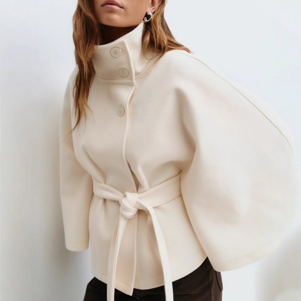Elegante cappotto a mantella bianco da donna con collo alto. Perfetto per la moda invernale e uno stile raffinato.