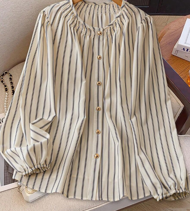 Top donna elegante a righe con maniche a palloncino. Maglia beige scollo rotondo, moda femminile versatile casual chic.