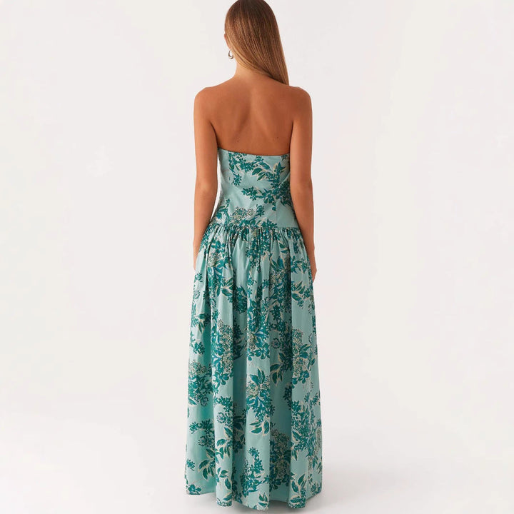 Donna in abito lungo senza spalline con stampa estiva verde e bianco. Look elegante e slanciato per vacanze o mare.