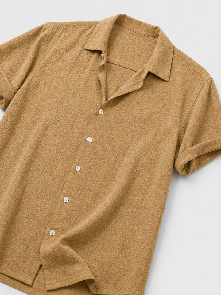 Modello camicia estiva uomo leggera in tessuto traspirante color camel dorato, ideale per il comfort e lo stile estivo.