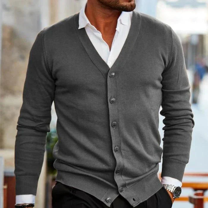 Uomo indossa cardigan scollo a V con bottoni, abbinato a t-shirt. Stile casual e confortevole per il tempo libero.