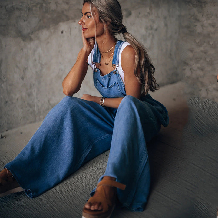 Tuta lunga da donna in denim blu con scollo a V, design comodo e gamba larga per un look casual chic estivo.