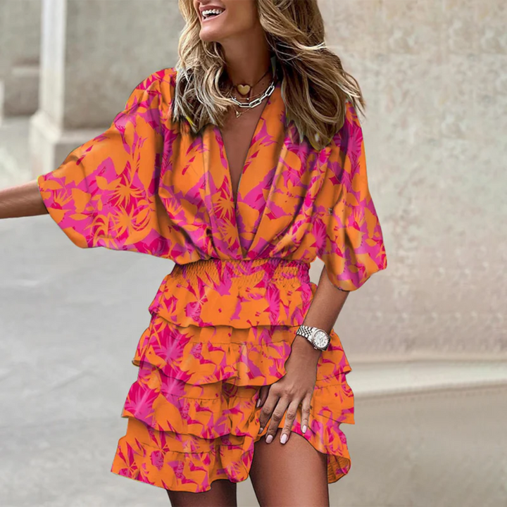 Mini abito estivo donna. Vestito corto e confortevole con stampa floreale e colori brillanti. Stile vacanza.