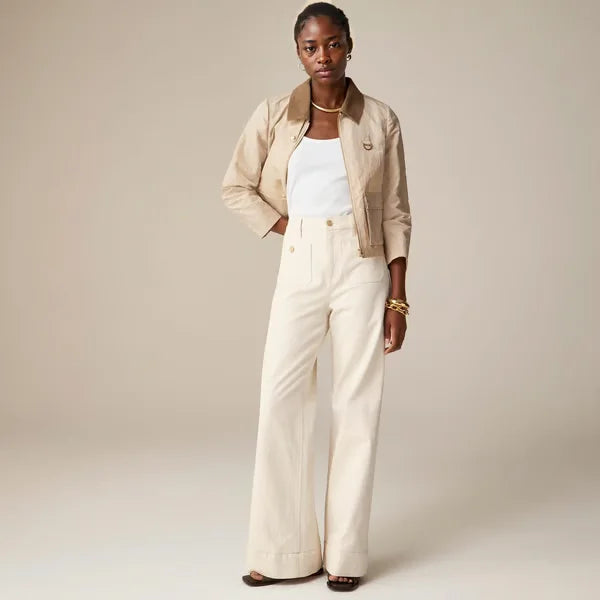 Dettaglio vita alta jeans donna, gamba larga. Chiusura e tessuto in evidenza.