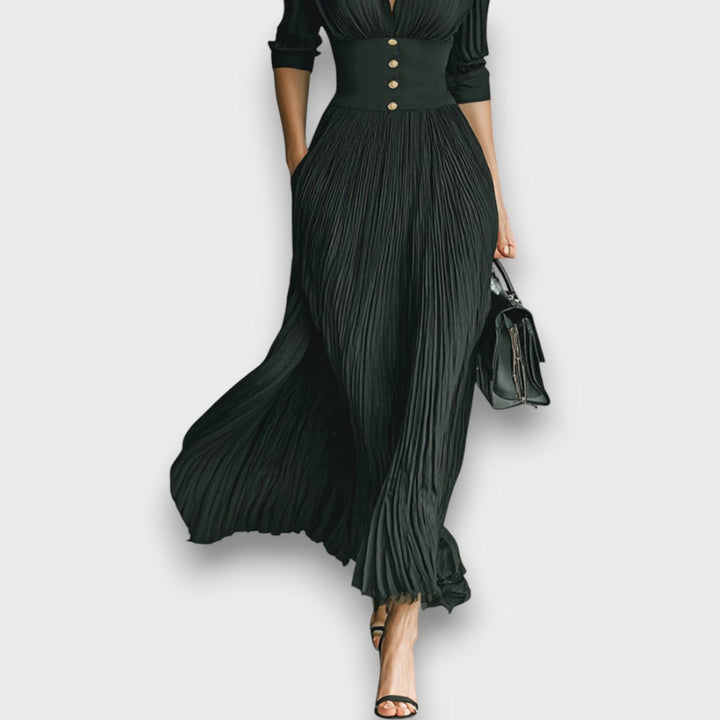 Abito lungo elegante da donna, con colletto revers sartoriale e gonna plissettata per un look sofisticato e formale.
