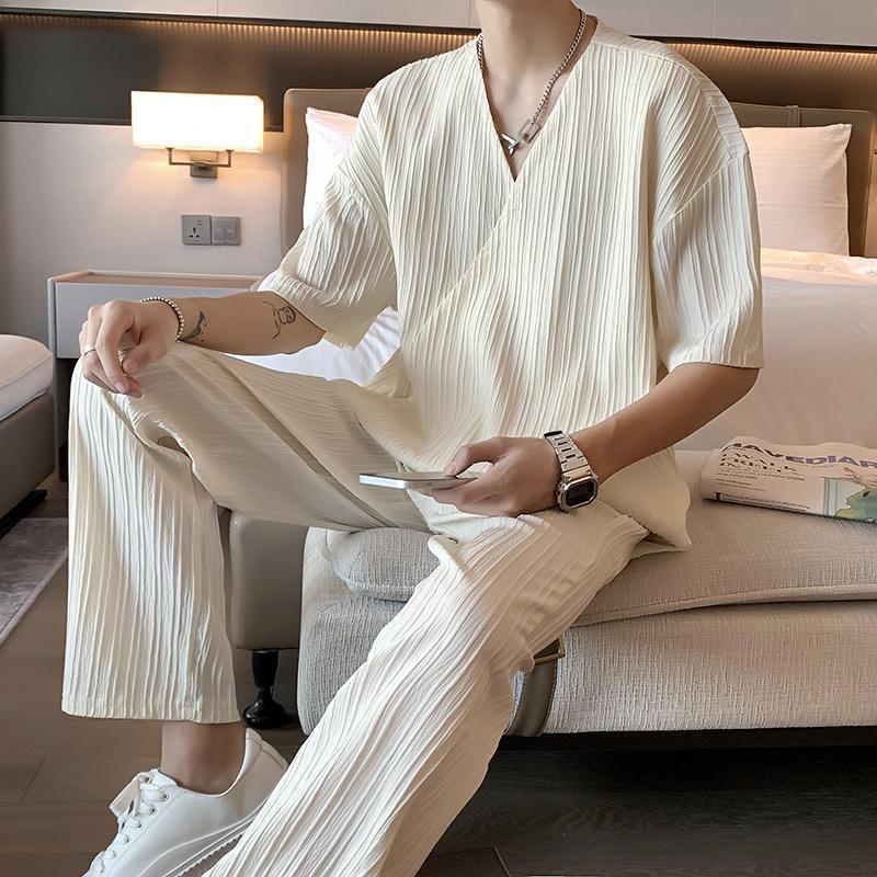 Outfit uomo casual estivo: completo due pezzi con camicia maniche corte e pantaloni dritti bianchi. Stile confortevole.