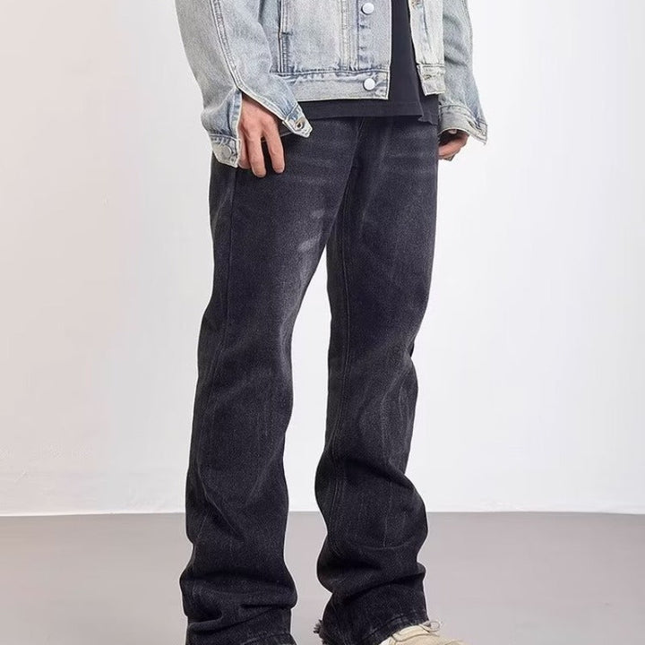 Jeans uomo svasati neri, con lavaggio effetto vintage e zone strappate, ideale per un outfit moderno e distintivo.