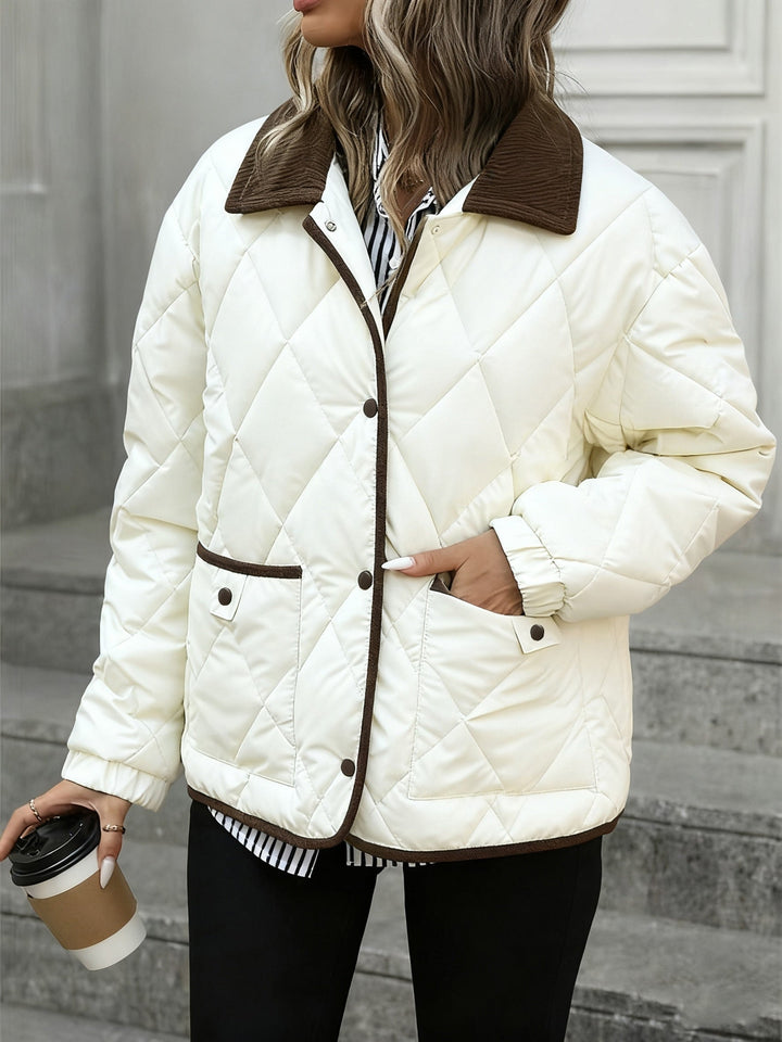 Donna che indossa giacca trapuntata marrone caffè, collo a contrasto, look elegante invernale. Moda autunno.