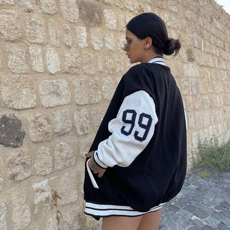 Donna indossa giacca baseball ricamata per l'autunno. Outerwear casual con maniche lunghe, look di tendenza.