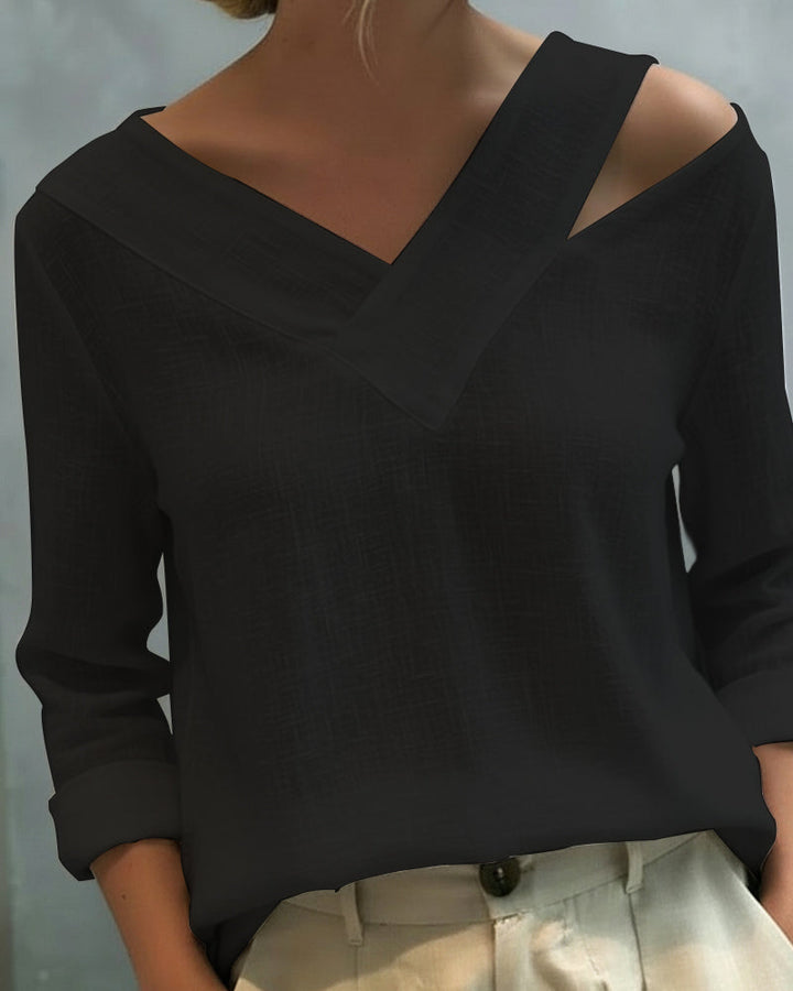 Top donna elegante nero con scollo a V asimmetrico, perfetto per look casual chic o da ufficio.