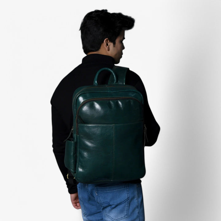 Zaino verde donna su sfondo neutro, mostra le linee minimaliste e il design elegante.
