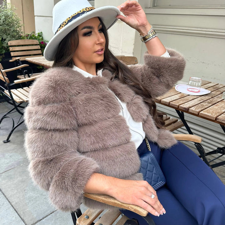 Giacca corta donna in pelliccia sintetica, collo tondo, vista da dietro. Stile elegante e moderno per l'inverno.