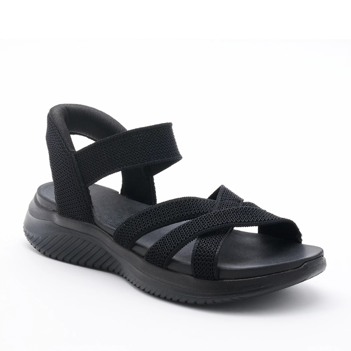 Donna che indossa sandali incrociati Flessia, unione di comfort e stile estivo versatile.