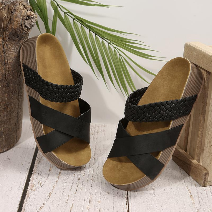 Piedi che indossano sandali donna intrecciati. Un design elegante per le tue passeggiate estive.