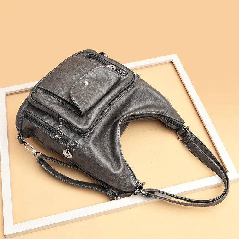 Primo piano della morbida pelle della borsa a tracolla da donna, texture lussuosa e dettagli curati.
