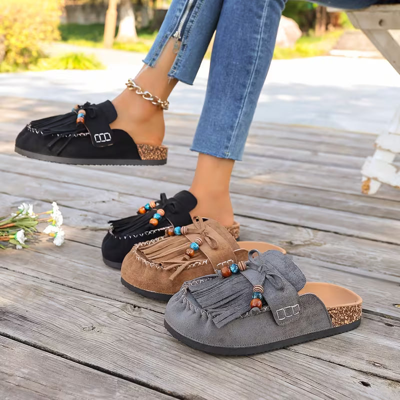 Sandali piatti donna con nappe e design boho, perfetti per l'uso quotidiano estivo.