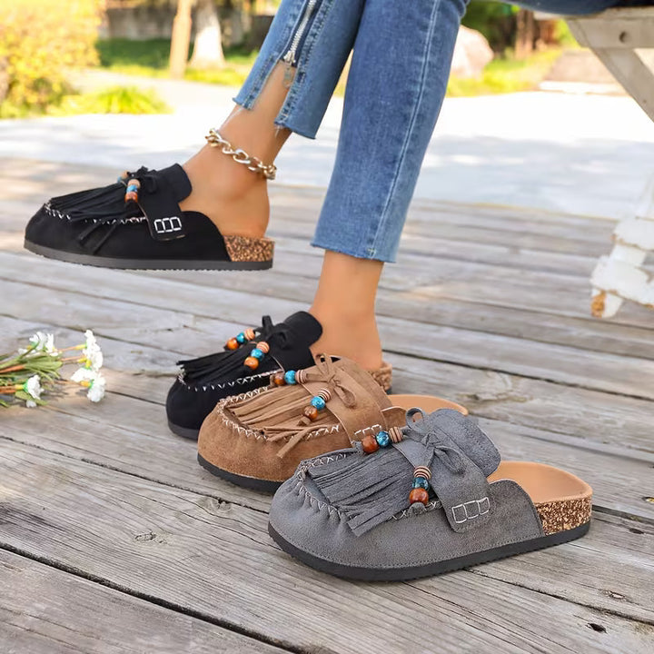 Sandali piatti donna con nappe e design boho, perfetti per l'uso quotidiano estivo.