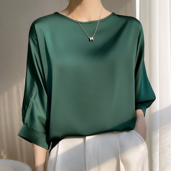 Blusa elegante da donna con scollo tondo e maniche corte. Tessuto leggero, ideale per la stagione calda.
