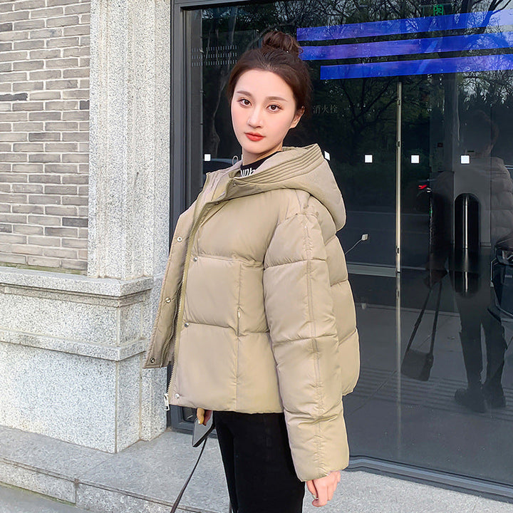 Modella indossa piumino corto donna, caldo, con cappuccio. Giacca invernale chic per il freddo.