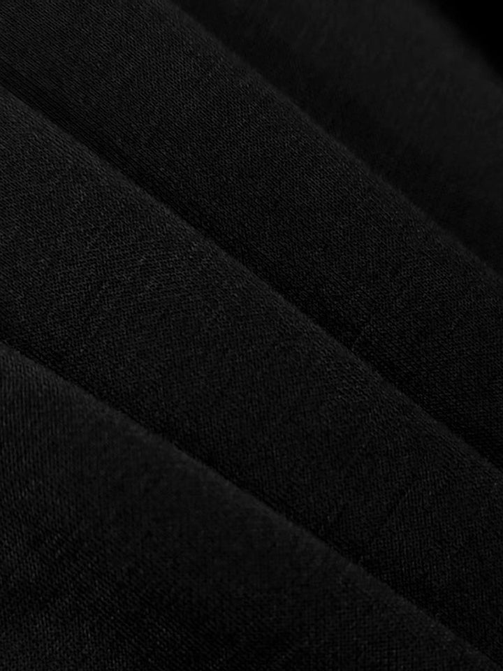 Vestito da sera nero, taglio maxi con spacco laterale, maniche a sbuffo e collo alto, per un'eleganza senza tempo.
