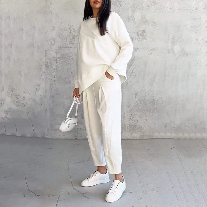 Completo streetwear donna: felpa asimmetrica e pantaloni a vestibilità rilassata. Look sportivo e di tendenza.
