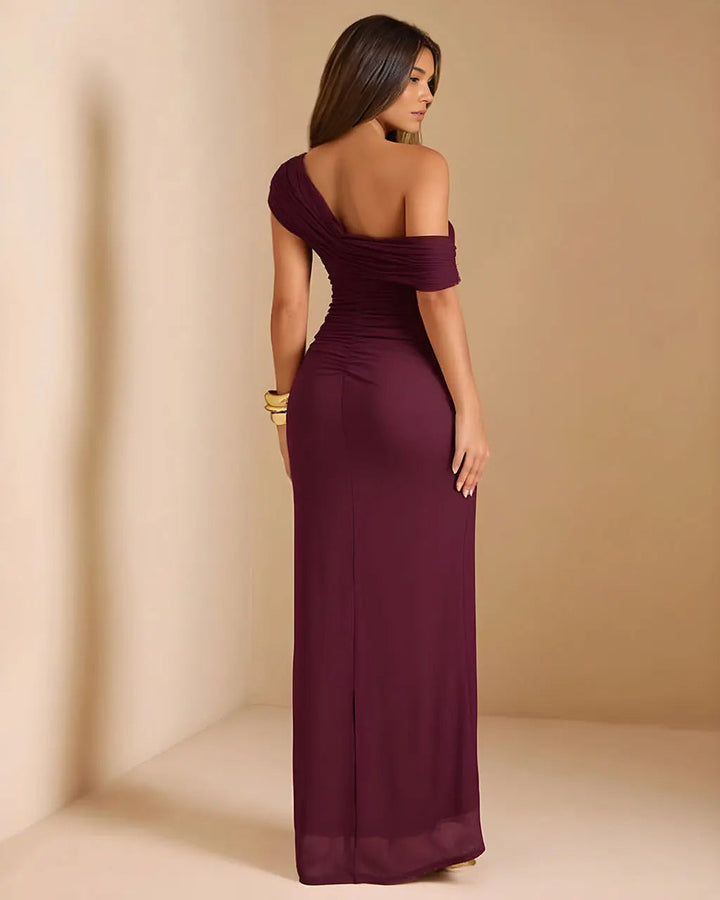 Donna indossa abito da sera maxi bordeaux, monospalla e arricciato, ideale per eventi eleganti e cerimonie.