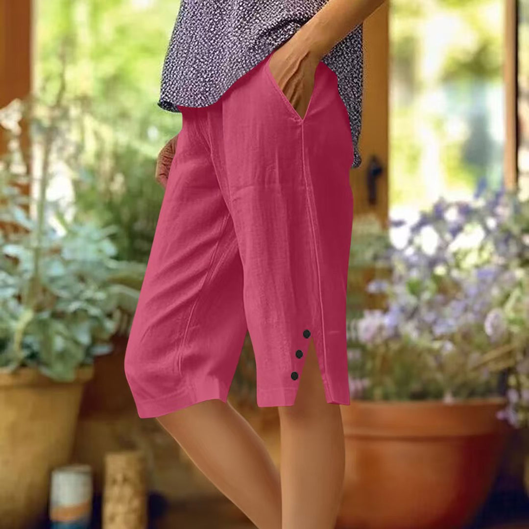 Donna che indossa pantaloni capri leggeri blu, ideali per relax e tempo libero.
